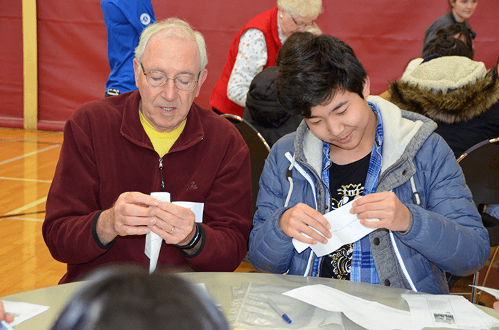 Intergenerational volunteers work side-by side to improve prairies