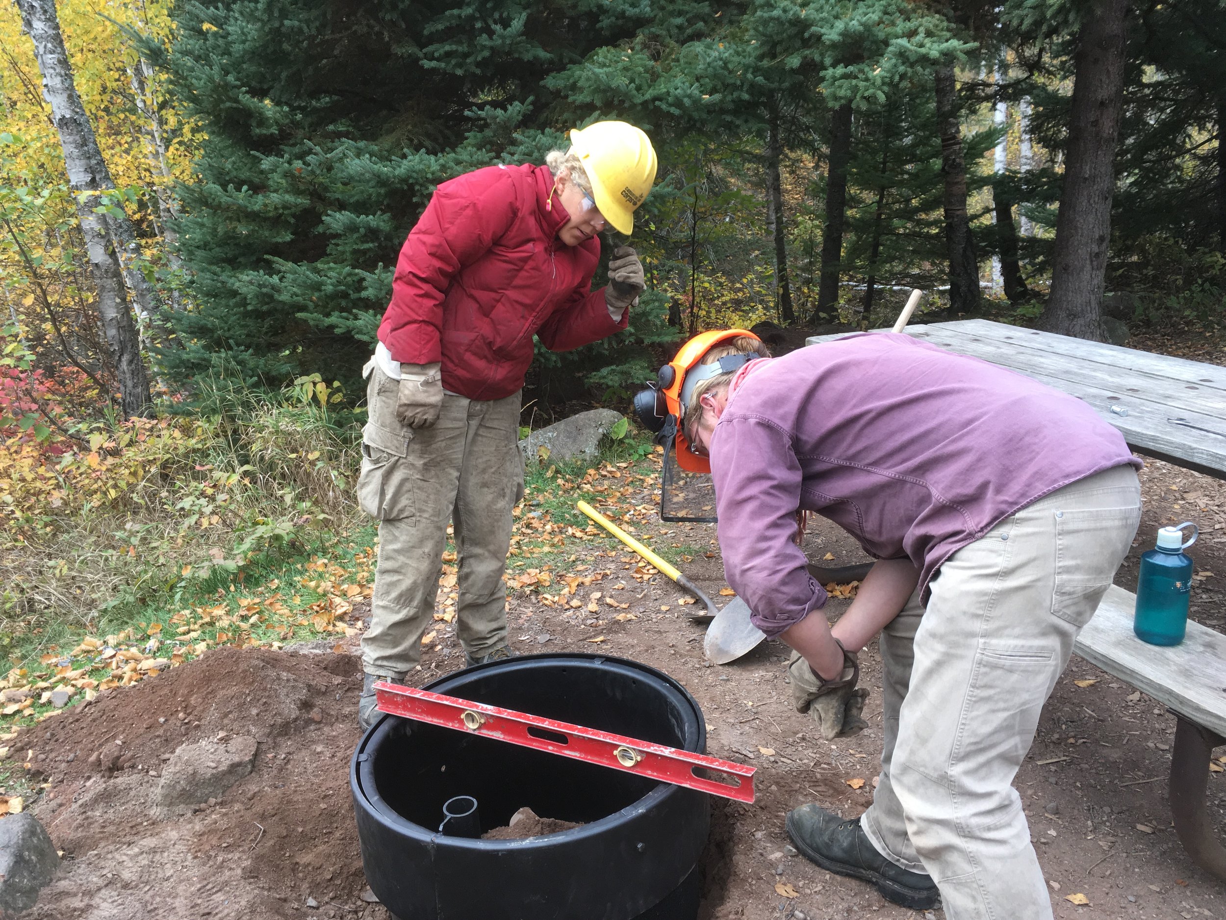 Two people installing fire ring