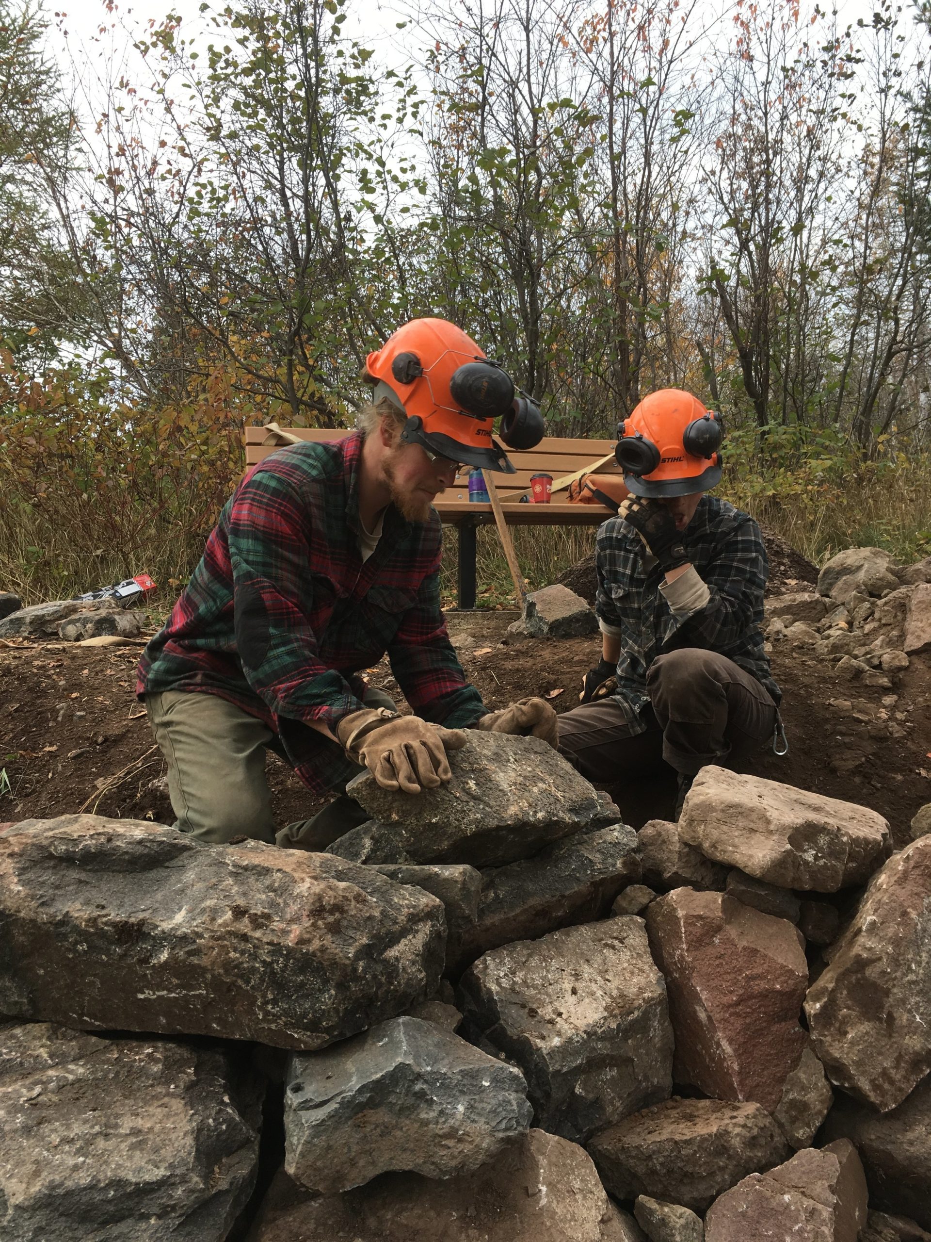 Moving boulders into place on trail