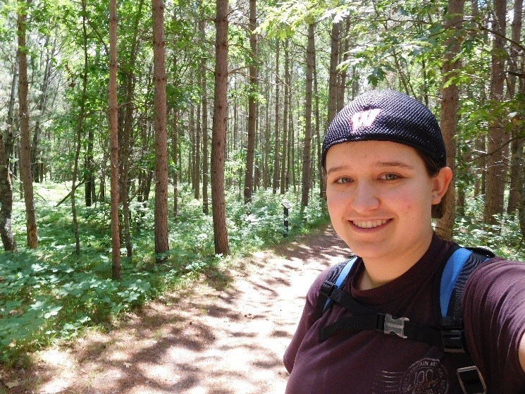 smiling at camera on a hiking trail