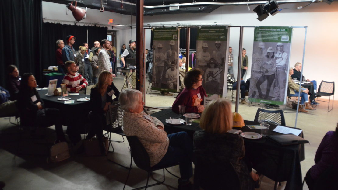 groups at tables with program banners