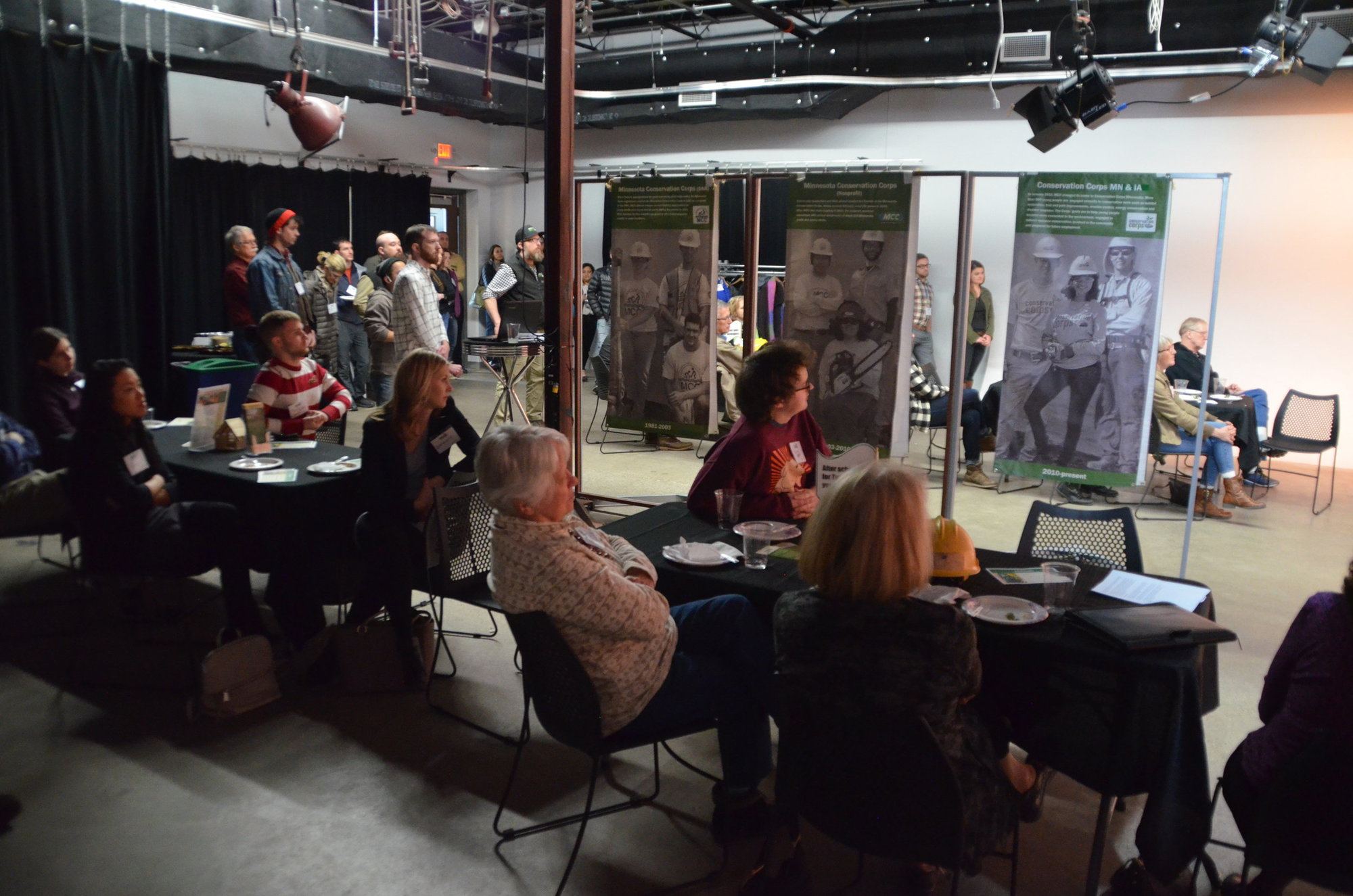 groups at tables with program banners