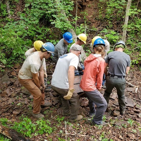 crew of 8 carrying boulder