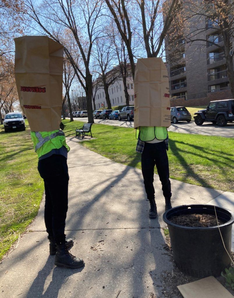 people with oversize paper bags on heads