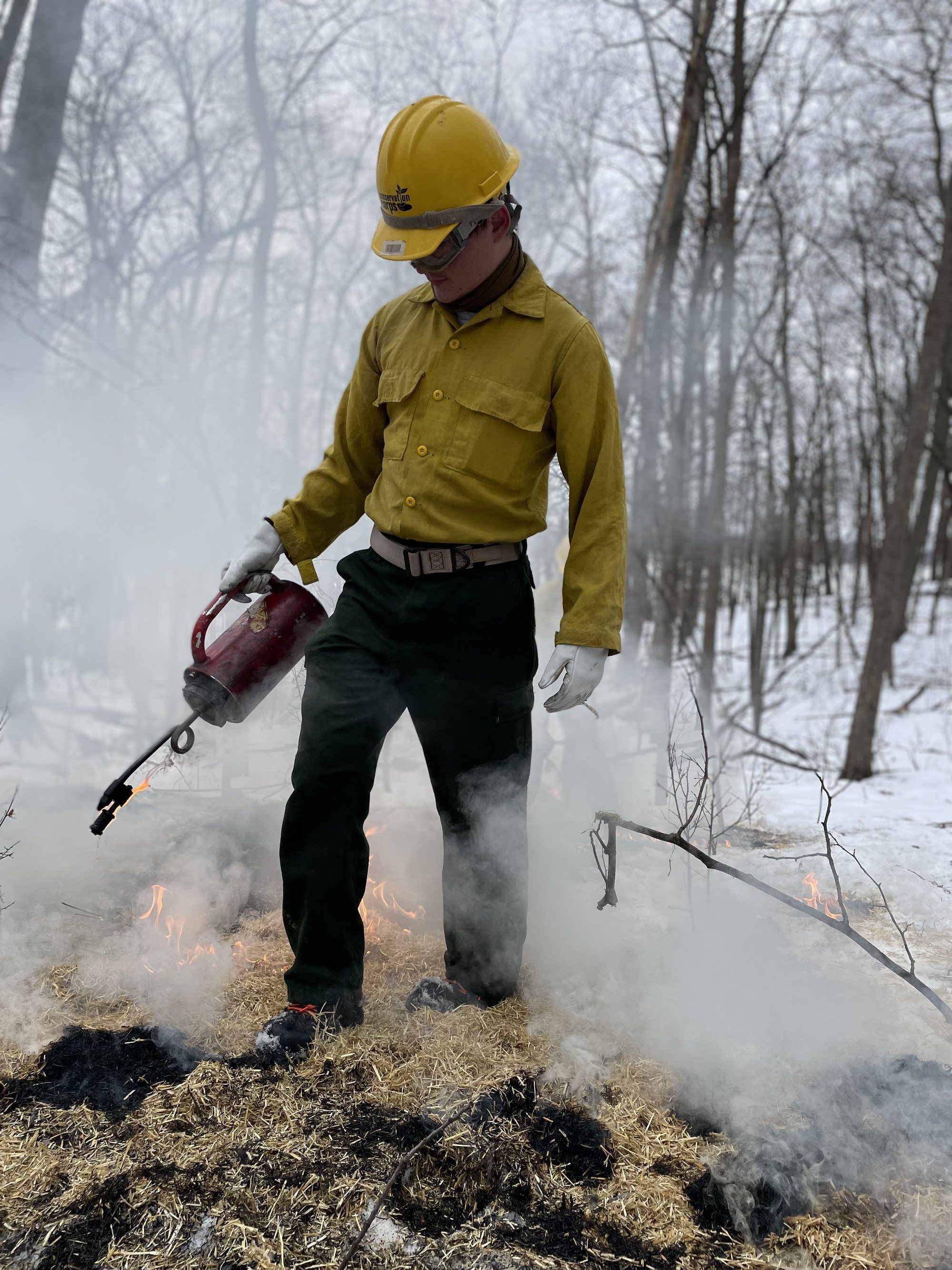 Corpsmember using drip torch to set fire