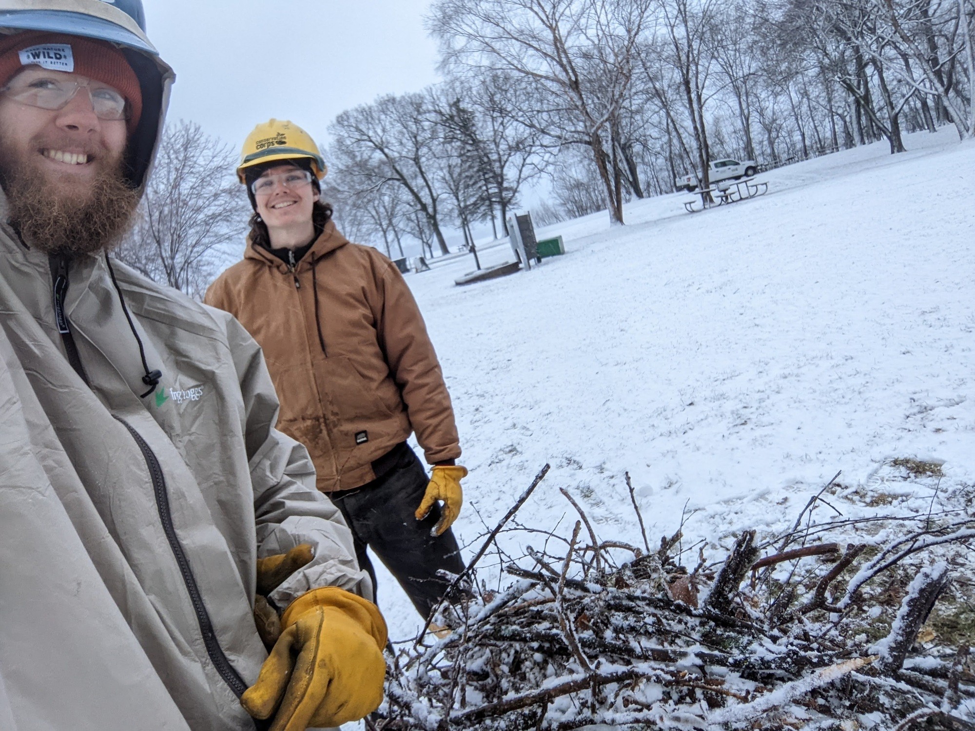 selfie of two members in hard hats in winter