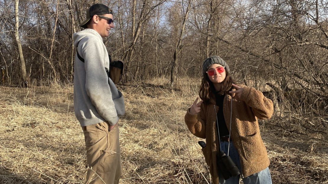 two people standing in dead tall grass