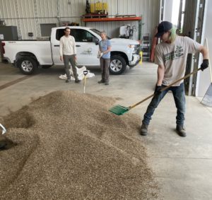 member shoveling seeds in shop