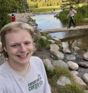 member standing in front of creek