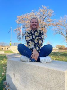 Person sitting crossed legged on a concrete slab