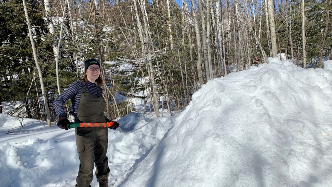 shoveling snow onto pile.