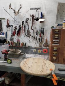 wire sticking out of a wood platter on a workbench