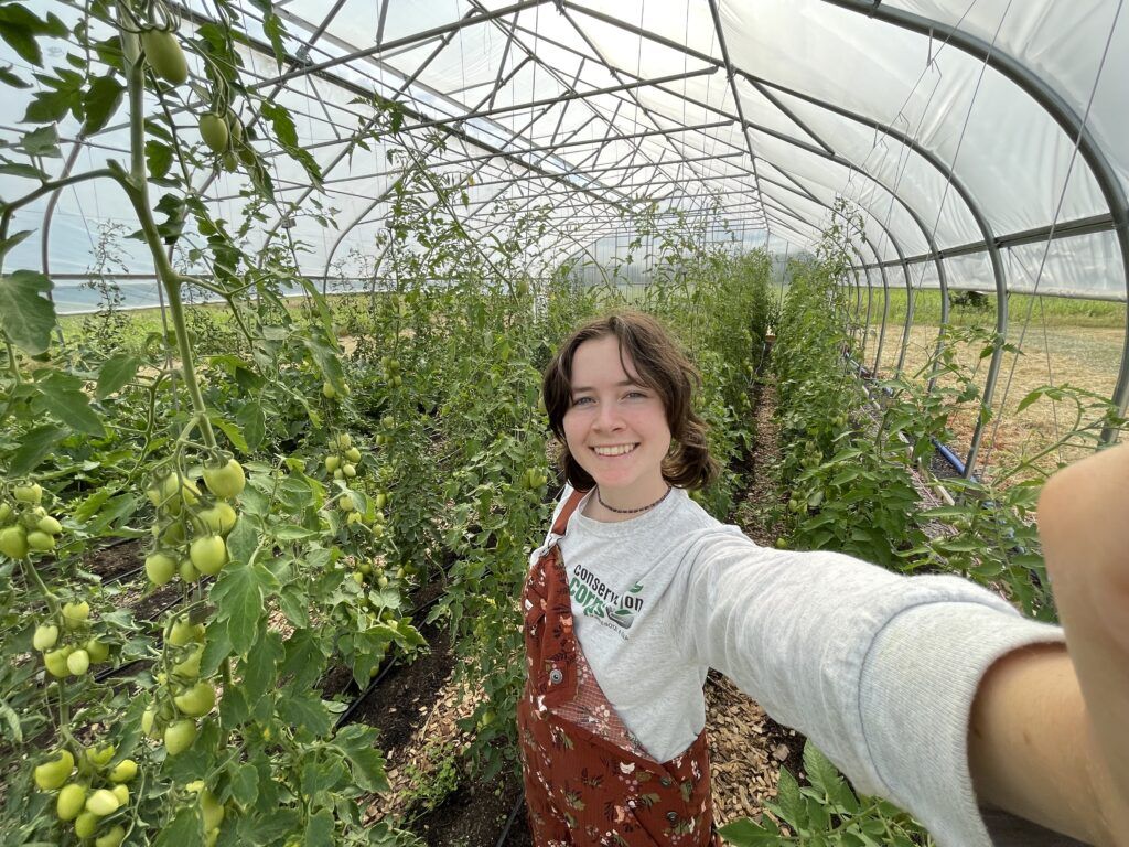 Kaden smiling with the tomato plants.