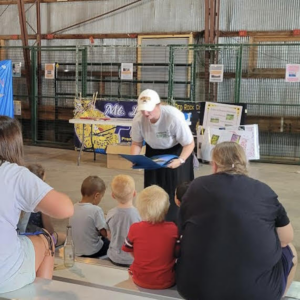 A person speaking to a group of children.