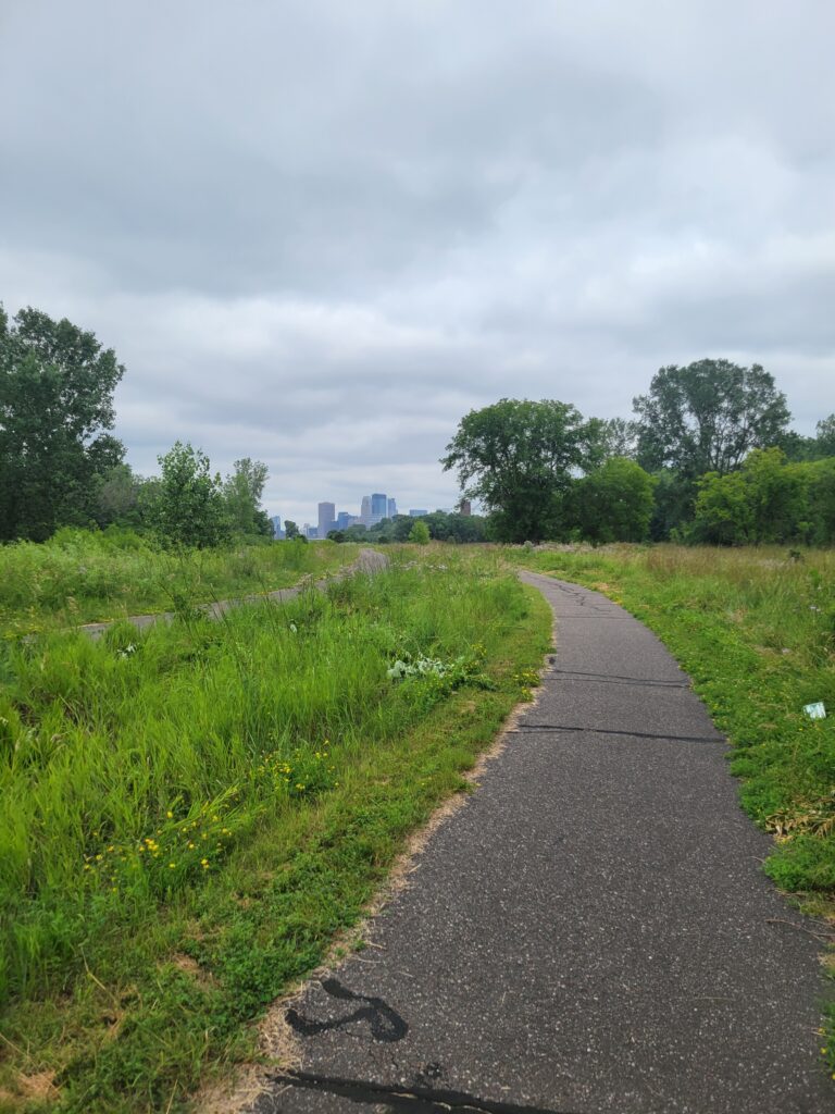 A paved trail in a prairie.