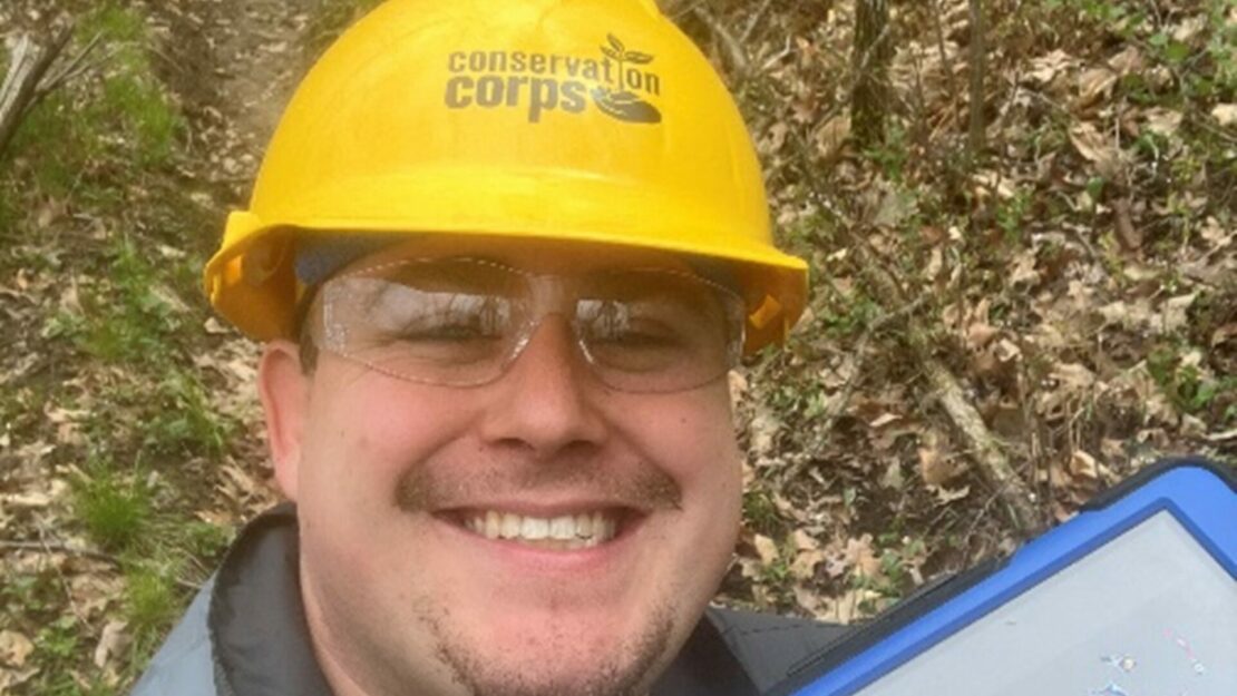 A person in a helmet smiling at the camera.