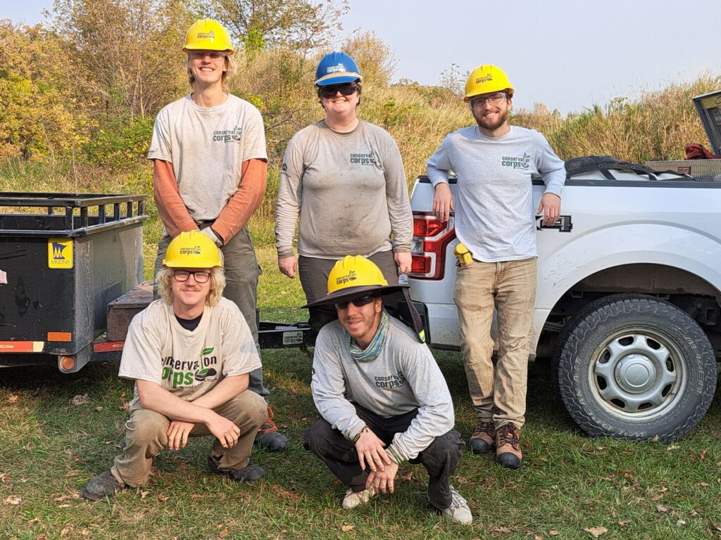 A group of people in Corps gear in front of a truck.