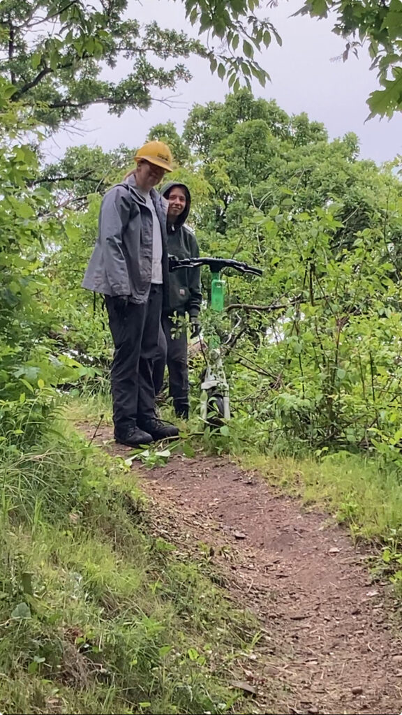 Two people holding an E scooter