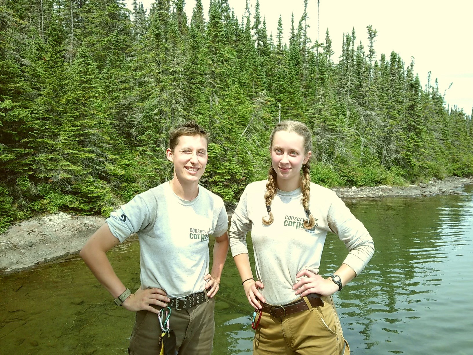 My colead Anna Knutson (left) and I (right) stand next to each other on the tree-lined shore of Lake Superior.