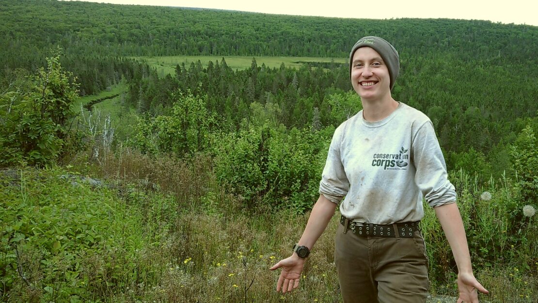A person in Corps gear standing in a natural area.