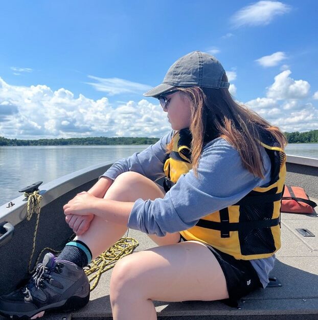 A person sitting in the front of a boat.