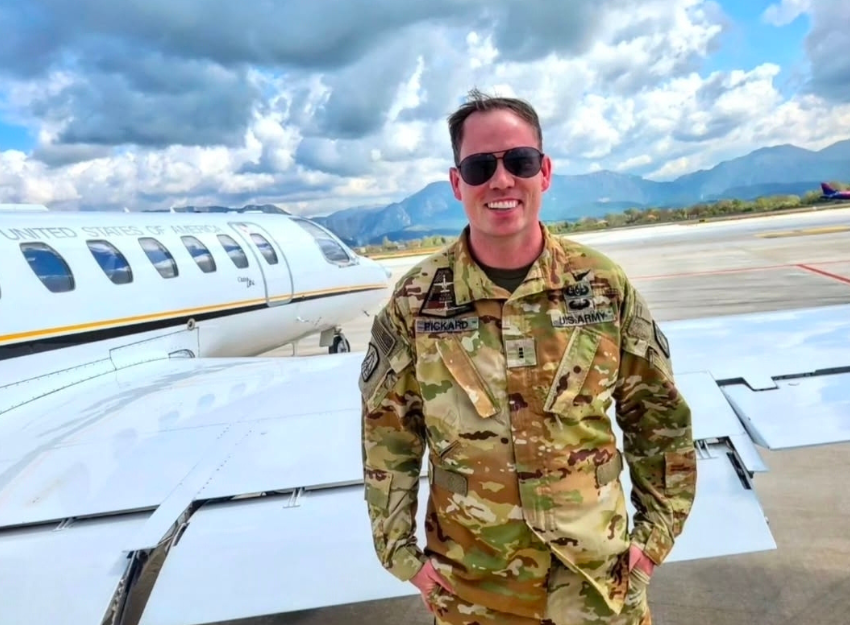 Alum Zach Pickard in his Army uniform standing next to a plane